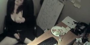 Busty business woman fucks a carrot at work