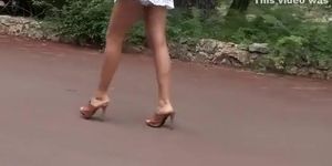 Leggy girl in heels and a dress filmed walking