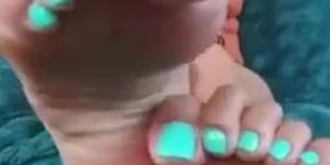 Curly haired asian girl exposing soles and turquoise toes