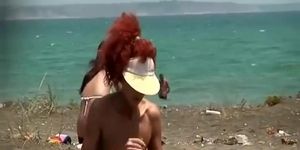 Redhead woman undresses bikini at beach