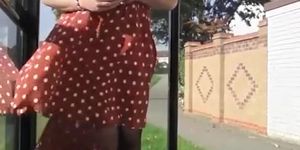 Wind lifts woman's red dress exposing her
