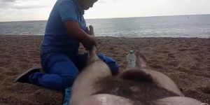 Hairy guy gets a leg massage on the beach