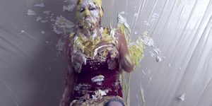 Bubbly young woman covered in pies and slime