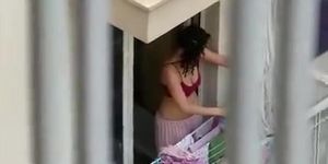 Lovely neighbor girl is hanging clothes