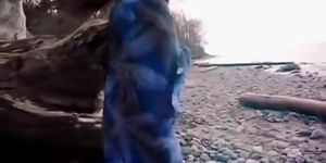Asian slut is on the beach naked posing