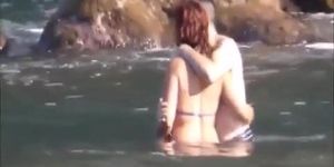 Horny couple having some fun in the water at the beach