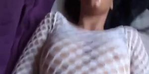 Horny brunette in a fishnet shirt playing with her pussy