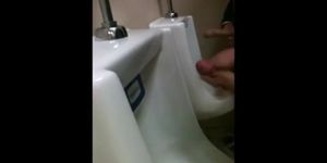 two slim dicks getting wanked at the urinals