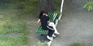 Teen couple making out in public park bench