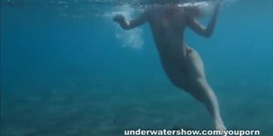 Julia is swimming underwater nude in the sea