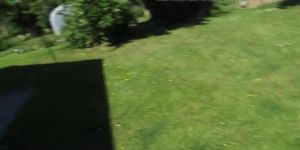 Masturbating hairy pussy in the garden with cars passing by