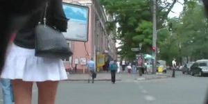 Voyeur video of a woman in high heels and white skirt
