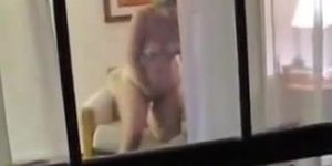 Naked mature woman voyeured masturbating through window