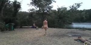 Slender nudist goes for a swim in the lake