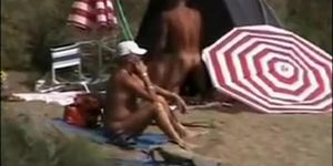Mature nudists copulating for an audience on the nude beach