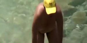 Mature nudist with yellow hat on her head