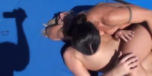 Two girls have a sexfight outdoors on a mat.