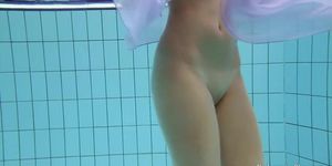 Floating virgin girl swims and strips underwater