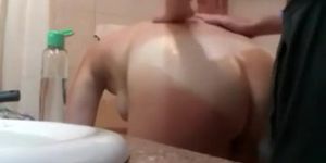 Bent over woman gets oiled up