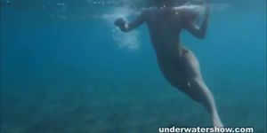 Julia is swimming underwater nude in the sea