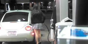 Short skirt girl putting gas in car