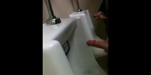 two slim dicks getting wanked at the urinals