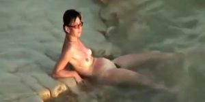 Hairy pussy nudist with glasses in the water