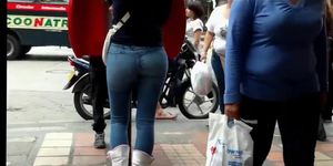 a beautiful round ass in jeans talking at a public phone