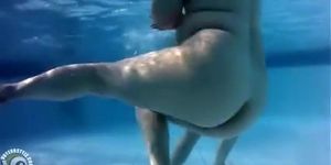 Underwater view with petite dipping nudist women and men