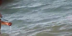 Topless girl playing on the beach and getting voyeured