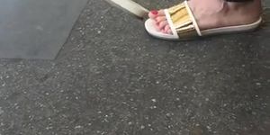 Sexy feet at London tube station, red toes dangling feet