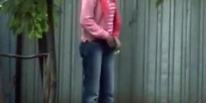 Blonde girl in tight jeans pants peeing outdoors