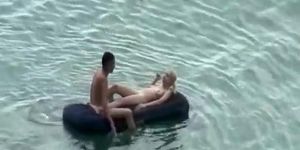 Group of nudist in air mattress in the water