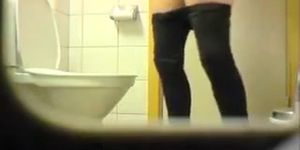Girl in leggings peeing in toilet