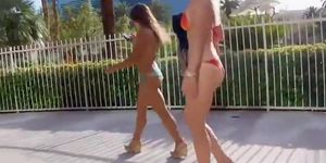 Two sweeties walk around the town in revealing bikinis