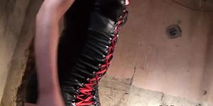Leather femdom stokes cock during bondage