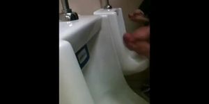 two slim dicks getting wanked at the urinals