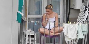 Candid blonde showing her feet on the fence in a way that reveals upskirt