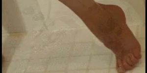 Young blond in shower uses sprayer to massage her clitoris and uses dildo
