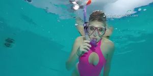 Woman snorkelling in the pool in pink swimsuit