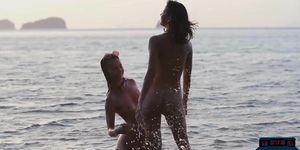 Lesbian Asian and European girlfriends playing in the ocean