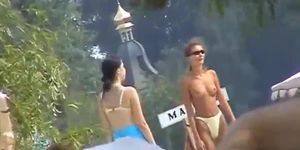 Voyeur video of a naked busty blonde spreading at the beach