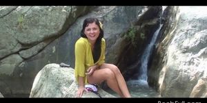 Amateur teen babe working her lusty twat by a waterfall