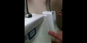 two slim dicks getting wanked at the urinals