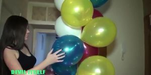 Brunette girl popping balloons