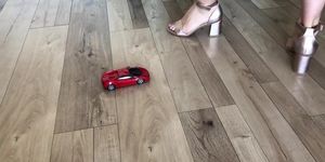 Woman crush toy car Lamborghini in high heels