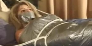Girl wrapped in duct tape and roped to bed