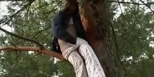 Amateur brunette is on a tree and peeing