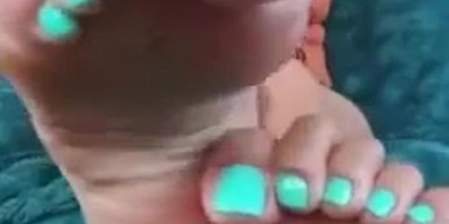Curly haired asian girl exposing soles and turquoise toes