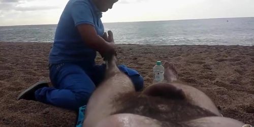 Hairy guy gets a leg massage on the beach